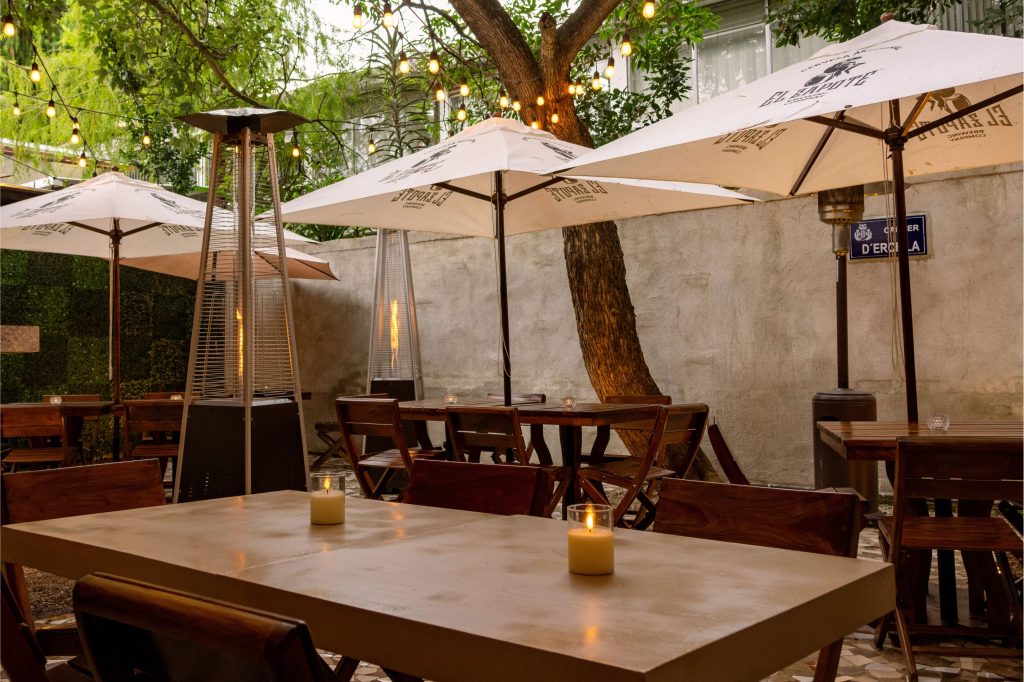 Patio iluminado de Terra Nostra Pizzería Gourmet en Guatemala, con ambiente nocturno encantador.